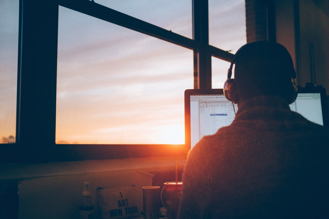 Man Working on His Desk by the Window
